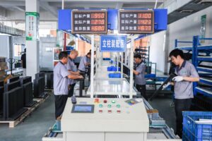 Contuo automated standing desk leg assembly line with dual-stage QC: workers inspecting ±0.1mm precision frame joints, conveyor belt feeding 45 legs/hour, ISO 9001 certified production facility.