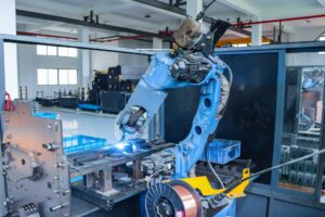 Contuo robotic laser welding system welding standing desk columns with ±0.05mm precision at 2m/min speed, KUKA industrial arm with real-time quality monitoring sparks.