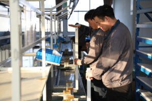 Contuo automated standing desk leg assembly line with dual-stage QC: workers inspecting ±0.1mm precision frame joints, conveyor belt feeding 45 legs/hour, ISO 9001 certified production facility.
